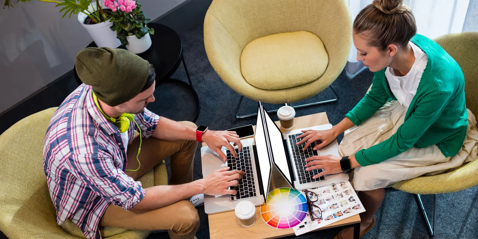 En kvinna och en man arbetar vid varsin laptop