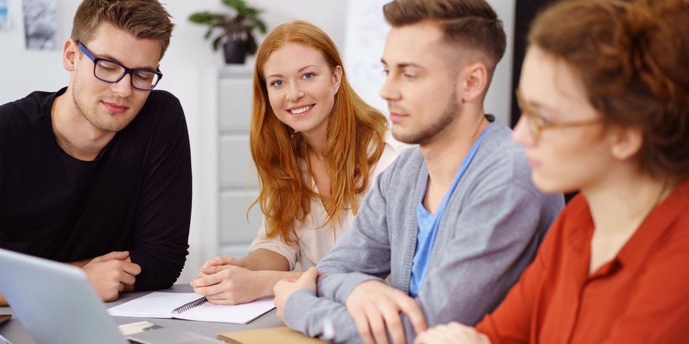 16181006-smiling-woman-with-coworkers-around-laptop-at-work - 3000x1500-compressor.jpg