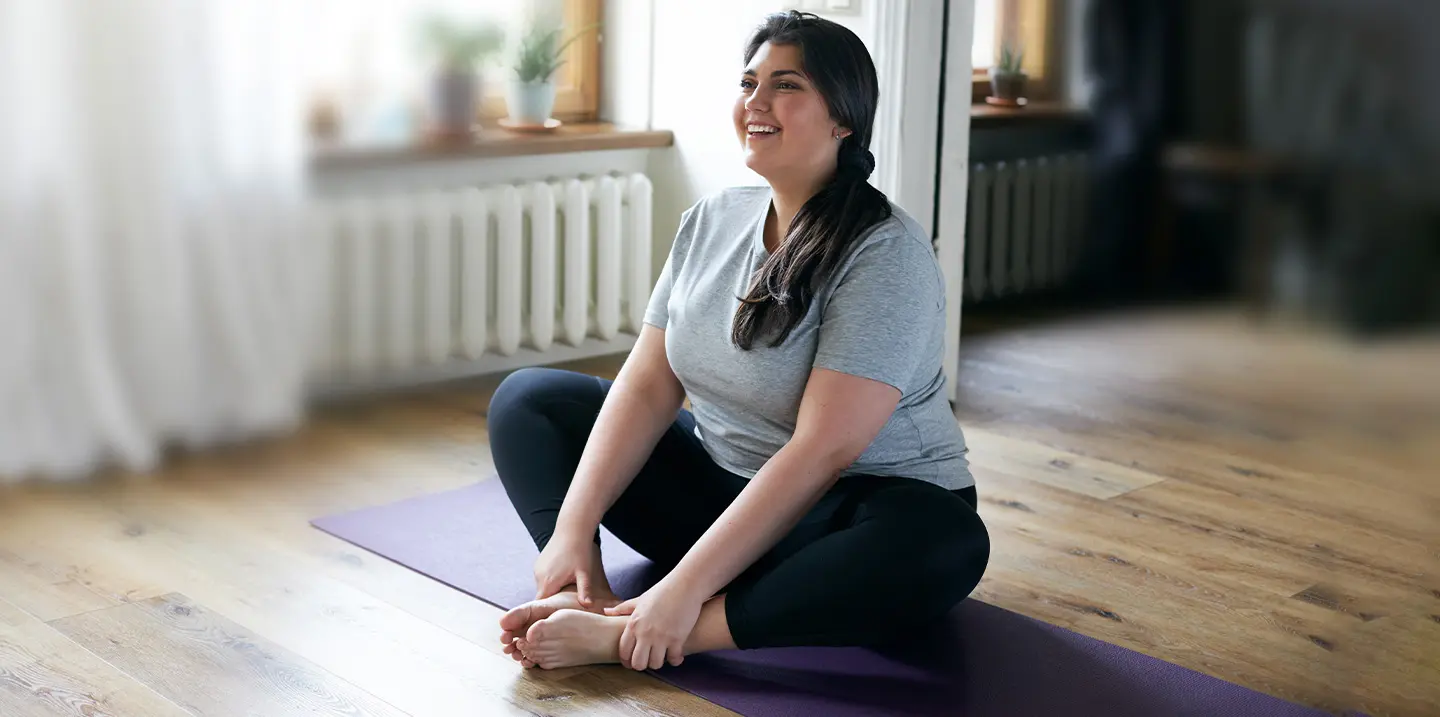 Kvinna i yoga-pose på parkettgolv